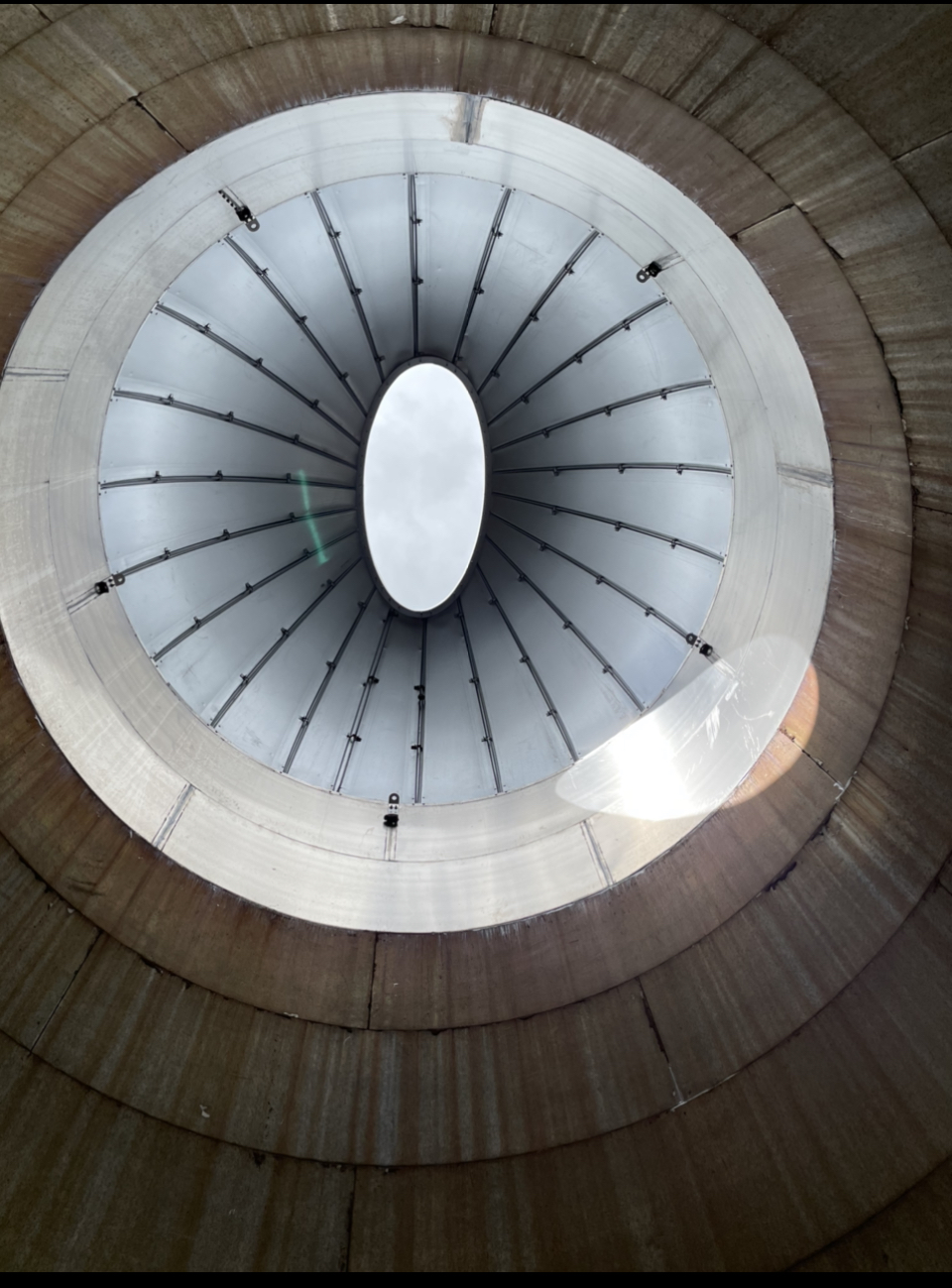 Inside a grain silo looking up, it looks like an eye looking back at me