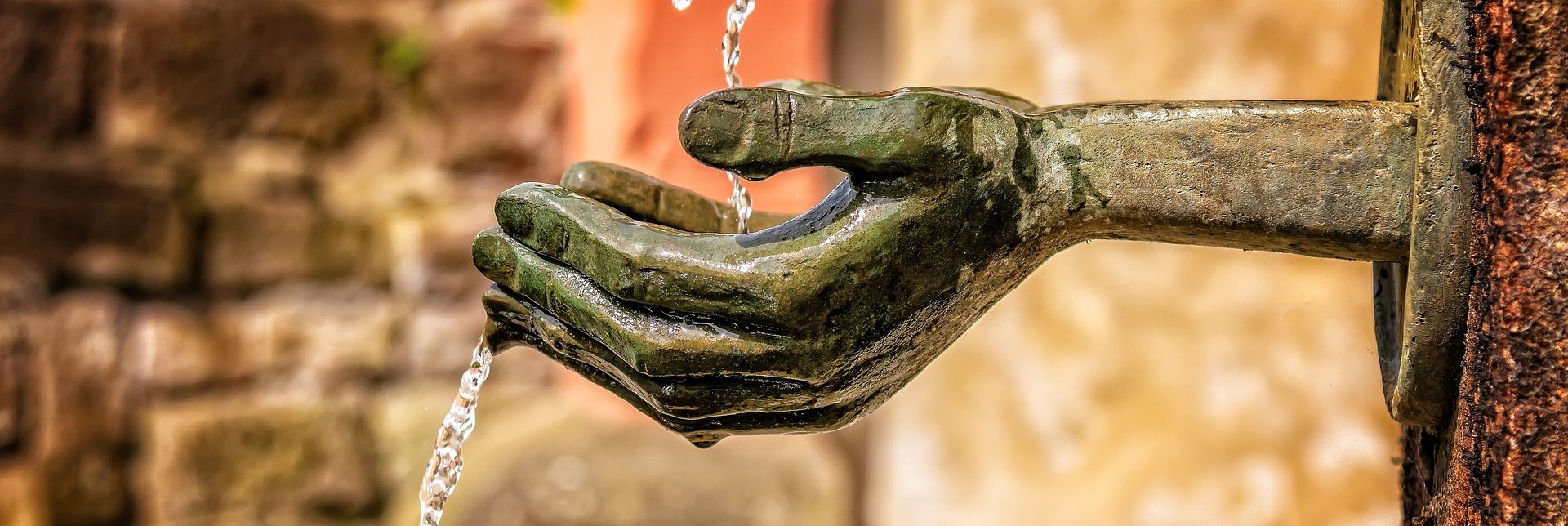 Refreshing water at a fountain with stone hands