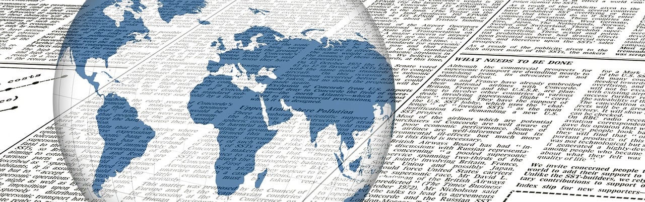 Globe of the world overlays a daily newspaper