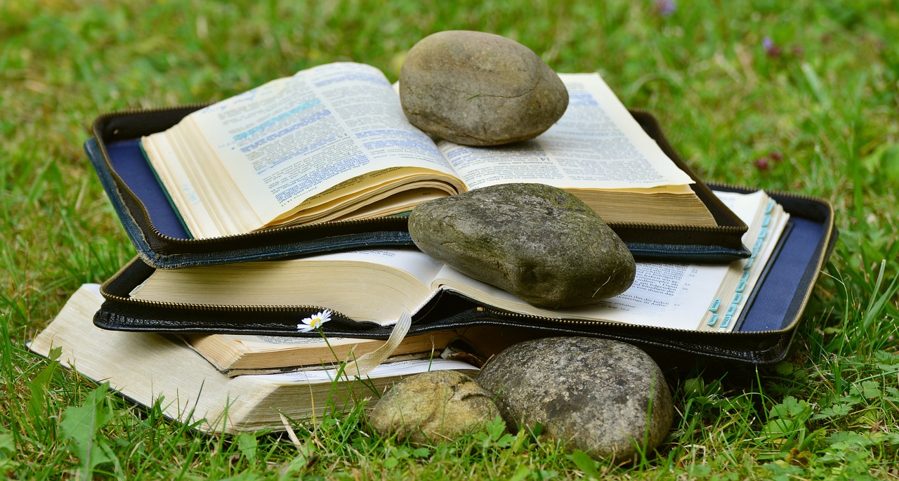 Bibles opened with a rock hold a marked place