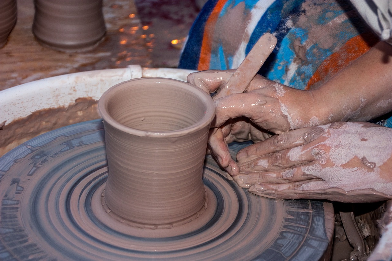 Potter shaping pottery on a spinning wheel