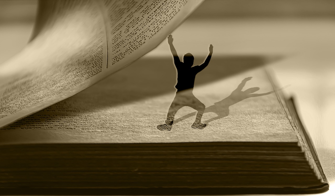 shadow holding up page of a book