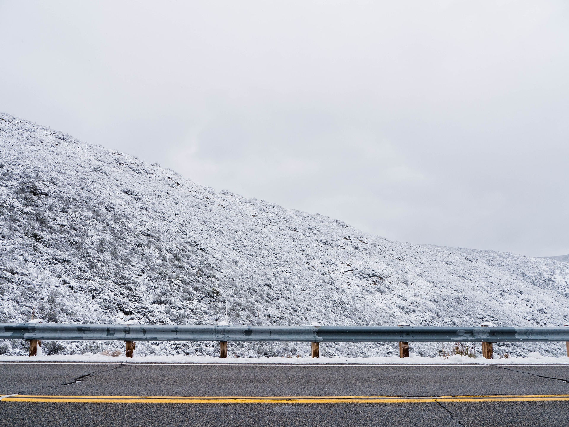 Guard Rail on a Snowy Highway Hill