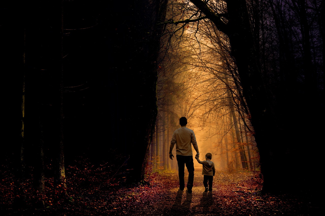 Father and son walking down a trail as the light fades