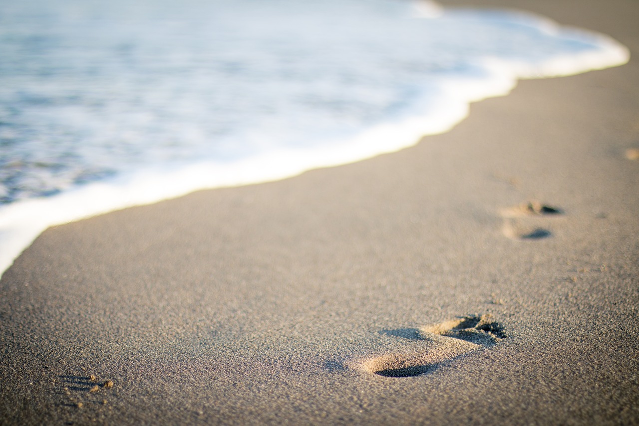 Barefoot steps on a sandy beach