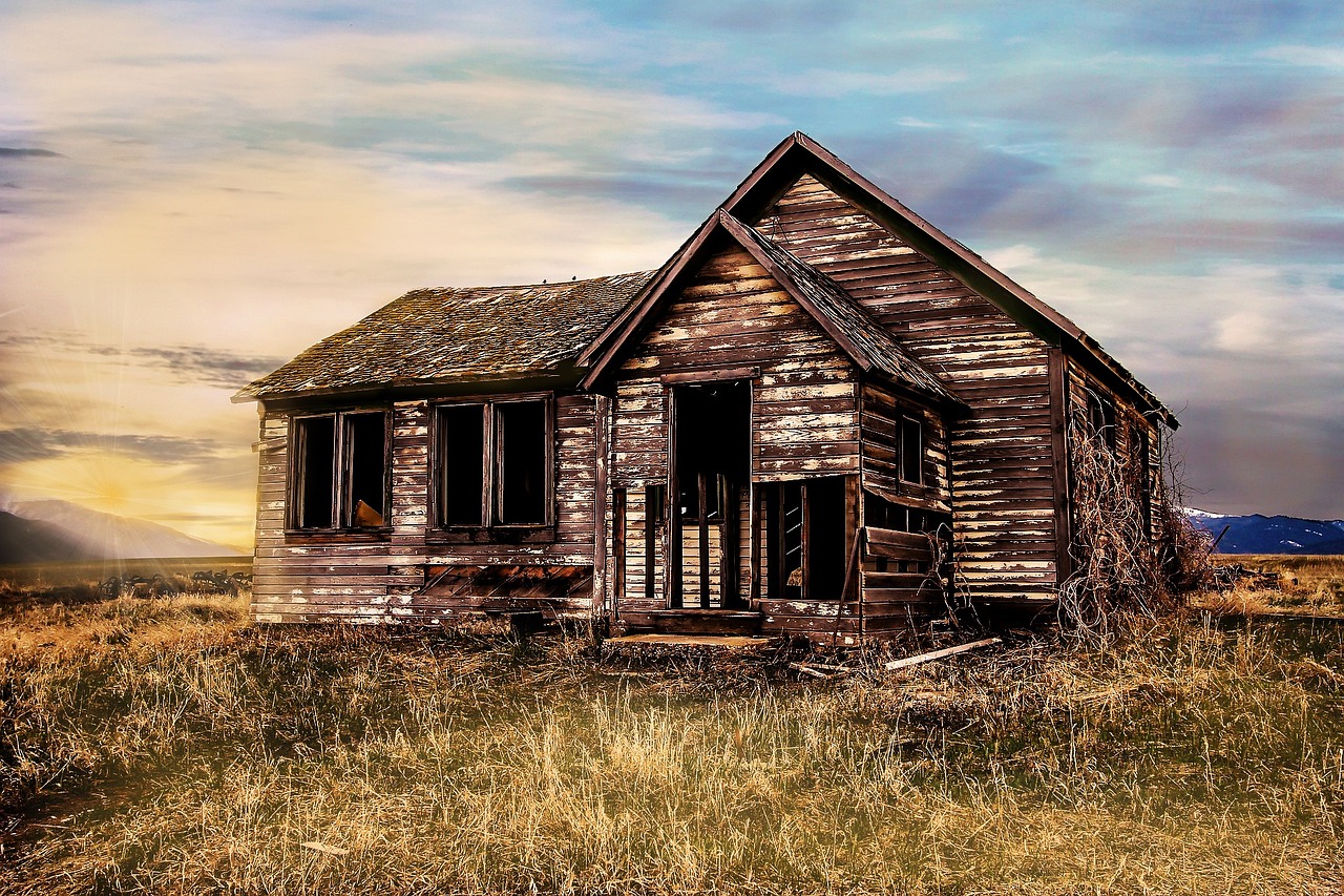 Forgotten and abandoned farmhouse with mountains in the background