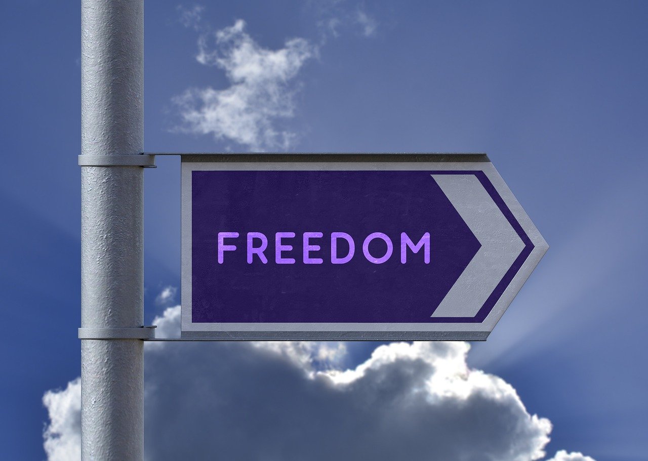 Choice sign reflecting Freedom with blue skies and darker clouds