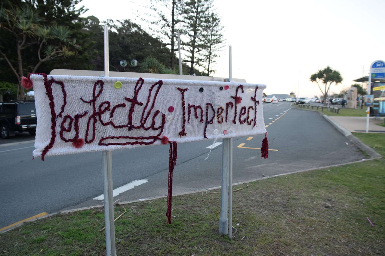 Sign stiched with words that say Perfectly Imperfect